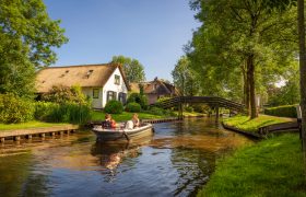 Giethoorn, Netherlands - May 30, 2018 : Tourists on a boat in the dutch village of Giethoorn. Giethoorn is often referred to as Little Venice, or the Venice of the North.